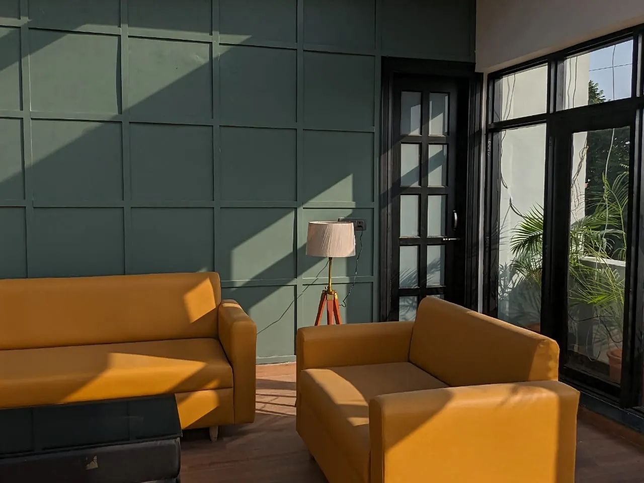 Sunlight across the geometric green living-room wall