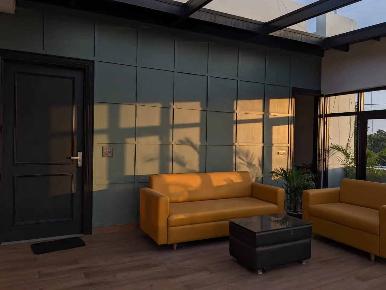 Mustard seating against a geometric green wall in Babbar Residency