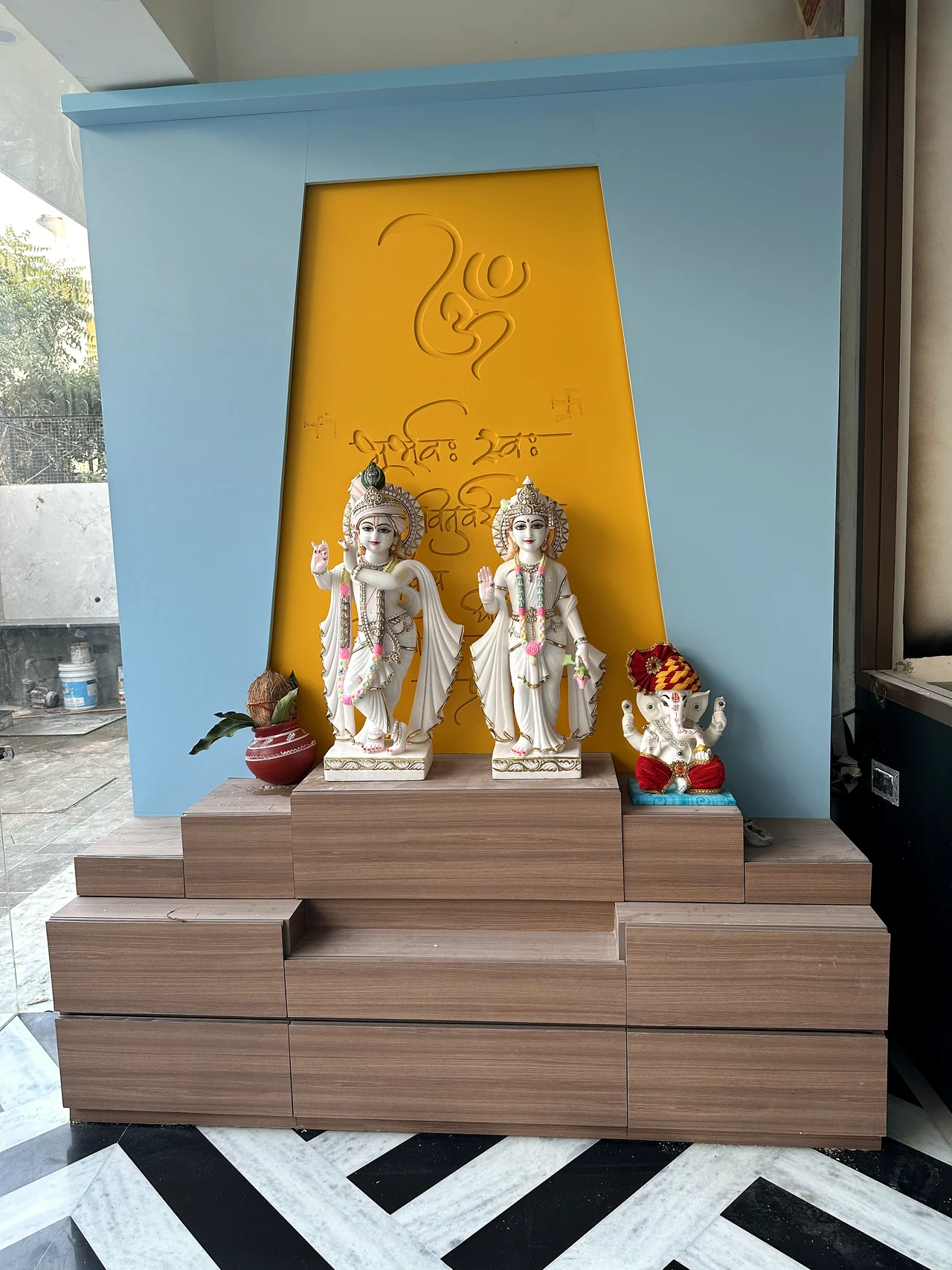 Puja alcove with a warm feature panel and built-in console