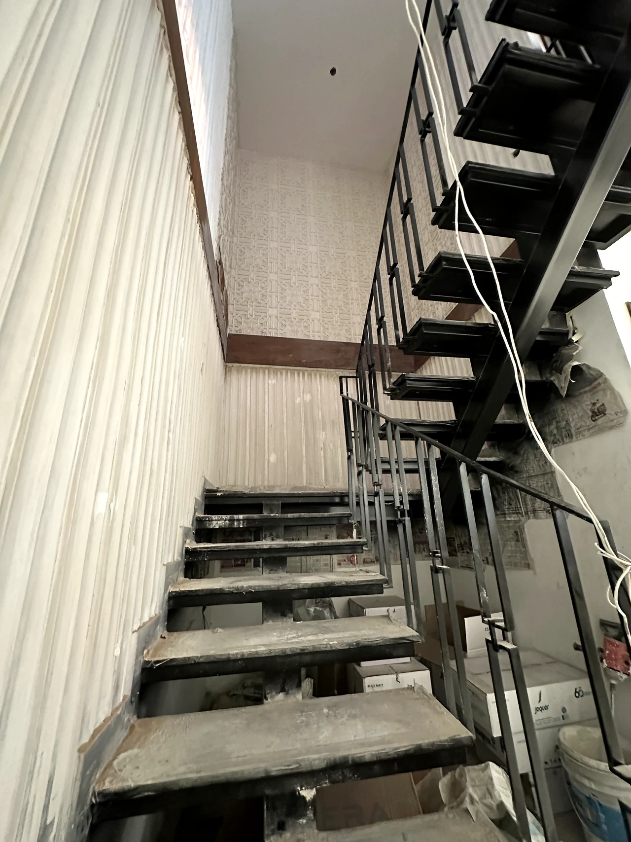 Steel staircase during installation, with its open risers and safety rails