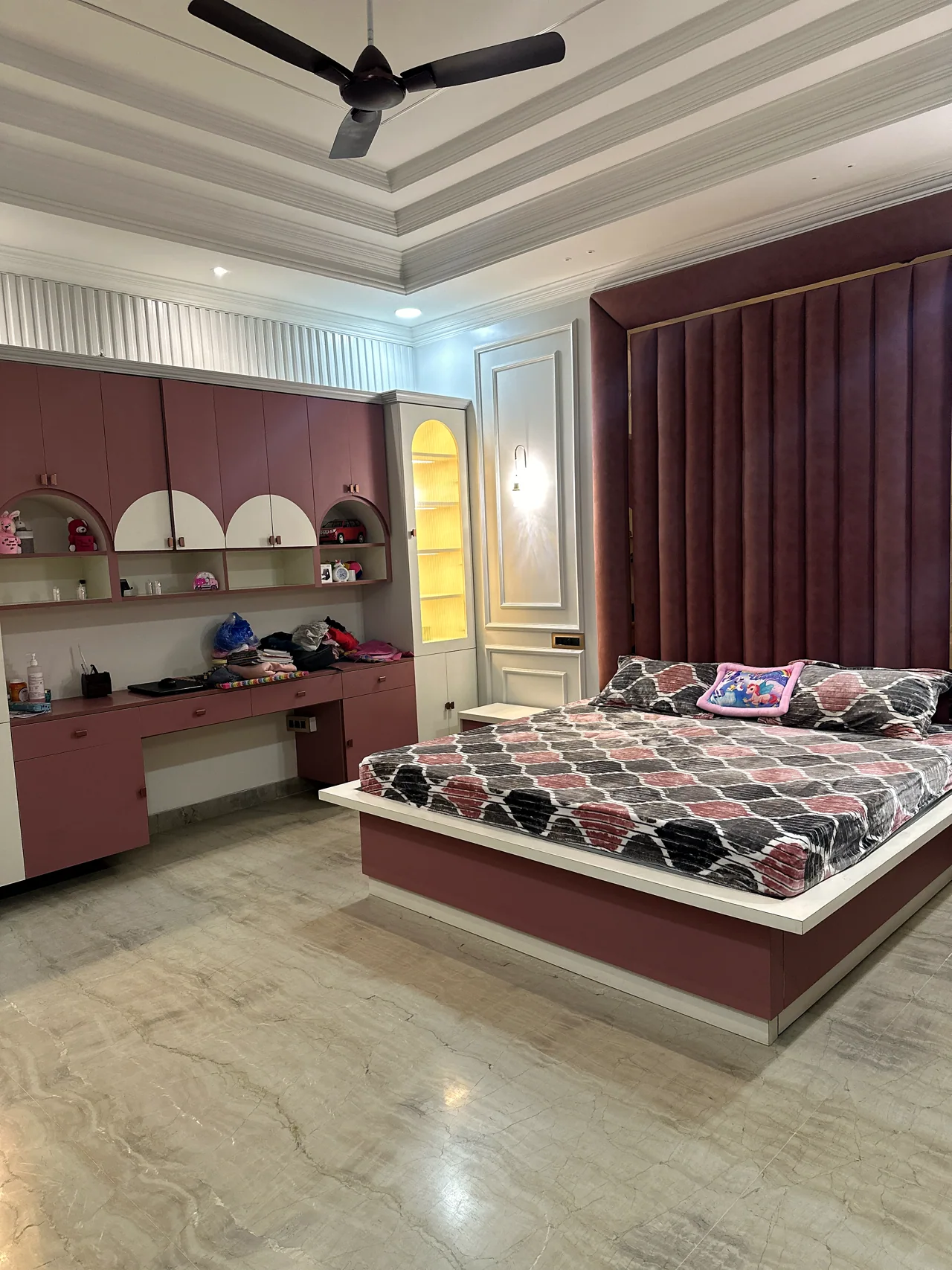 Bedroom seating, bed and display niche in a rose palette