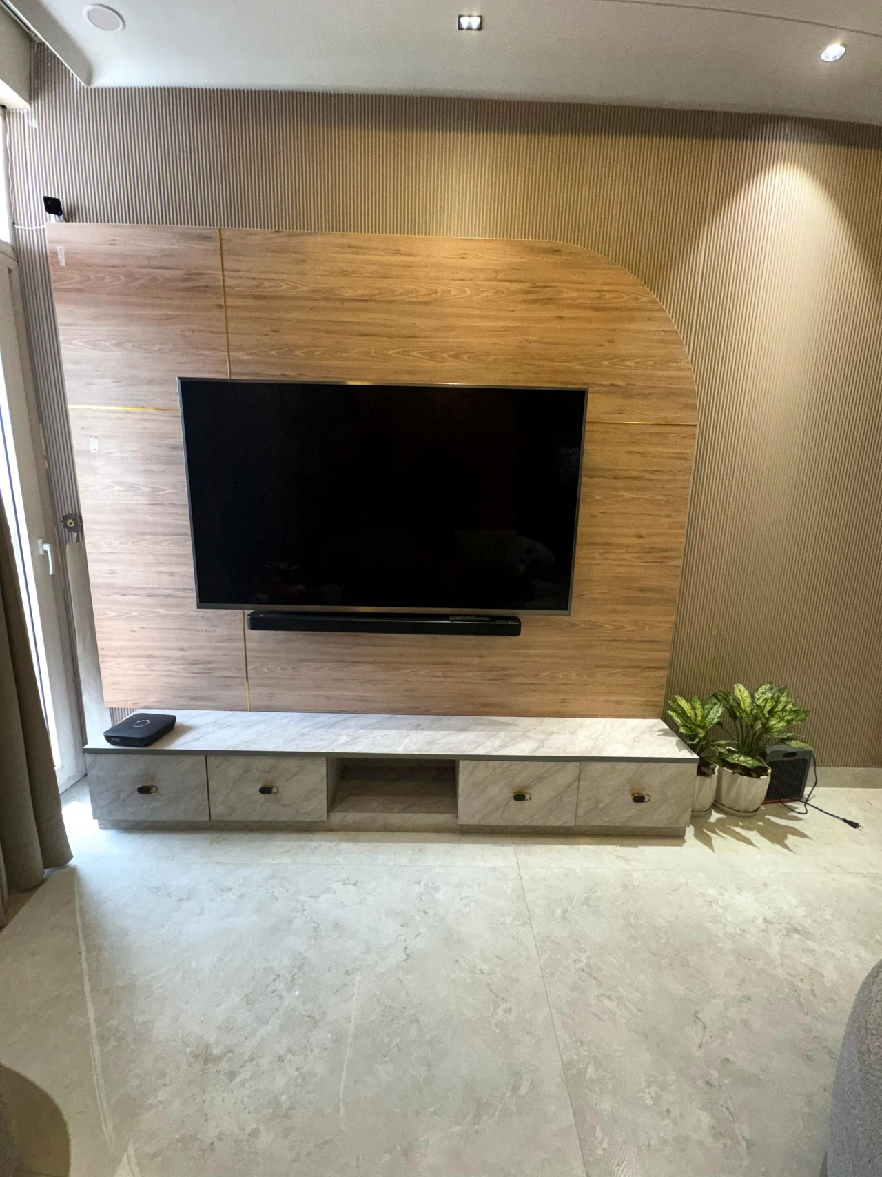 Floating media console and television on a textured neutral feature wall